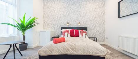 Desk, laptop workspace, iron/ironing board, bed sheets