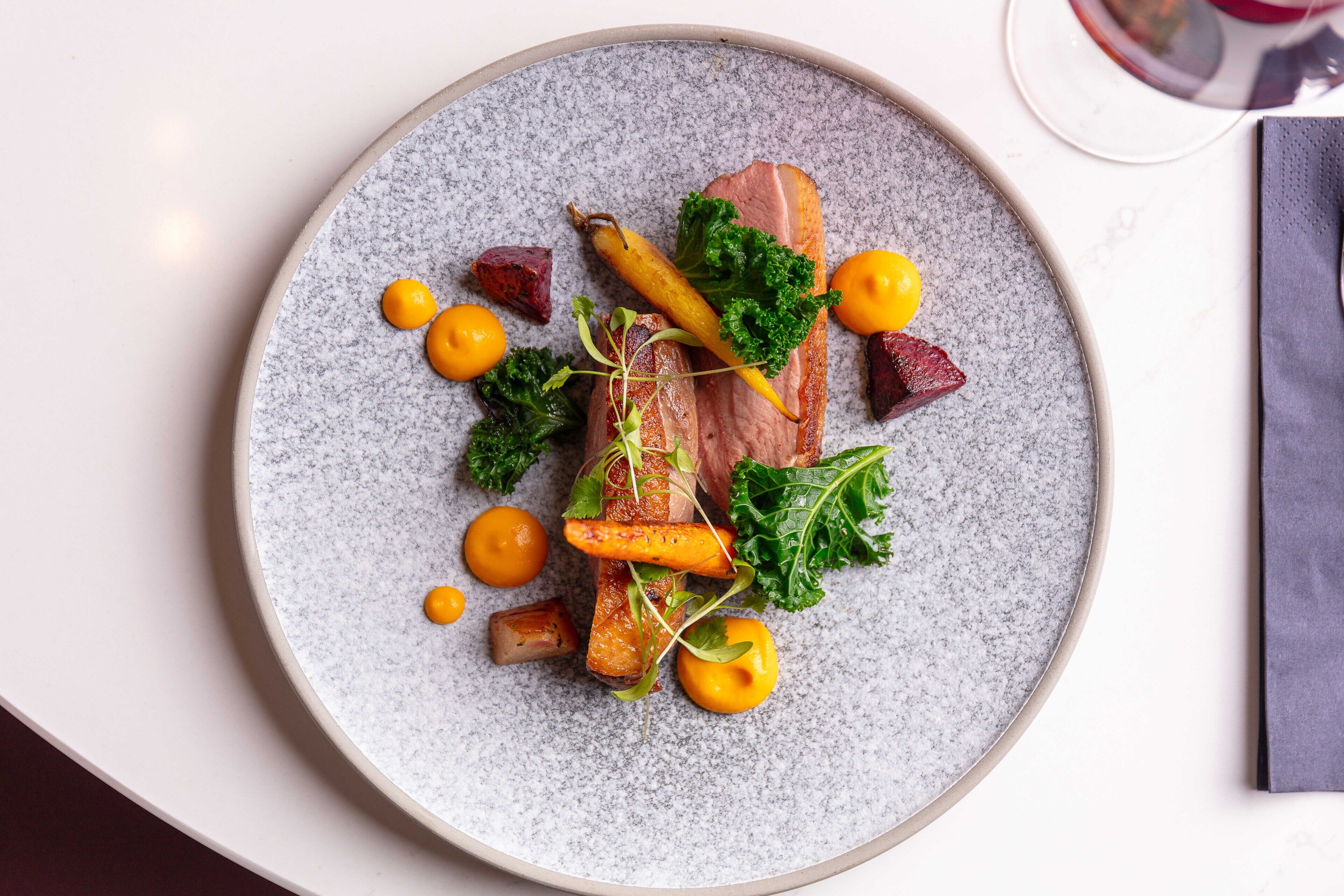A plate of food with various vegetables and a piece of meat.