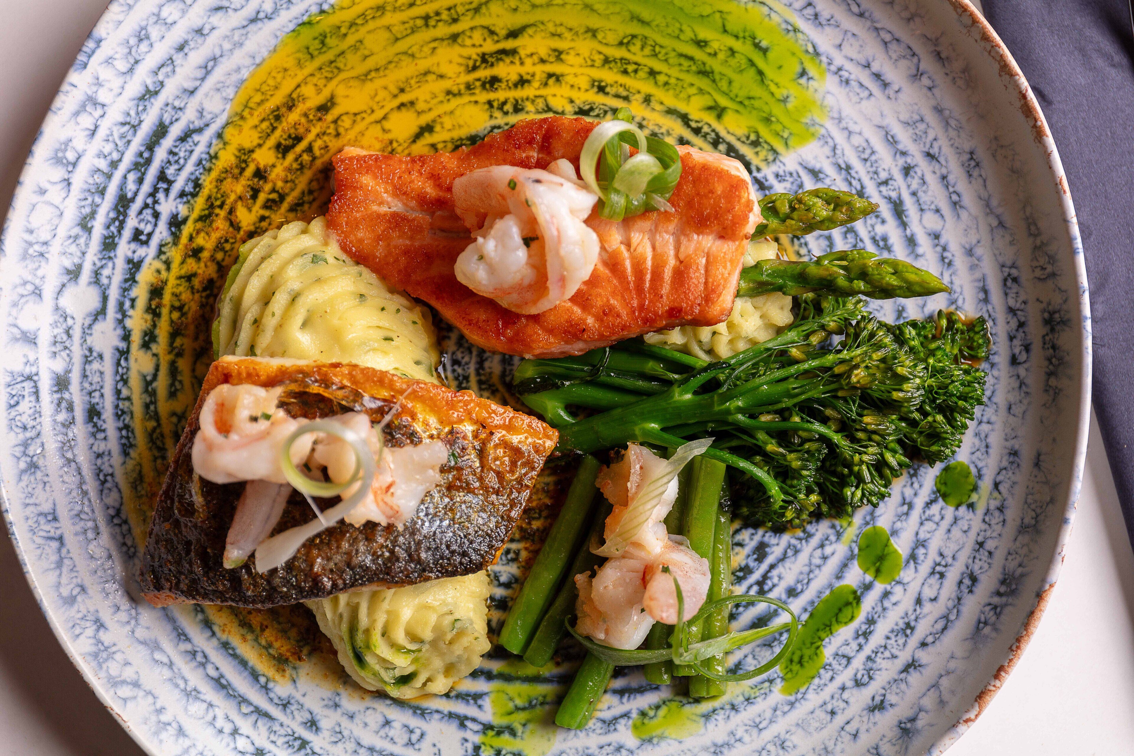 A plate with salmon, asparagus, and shrimp.