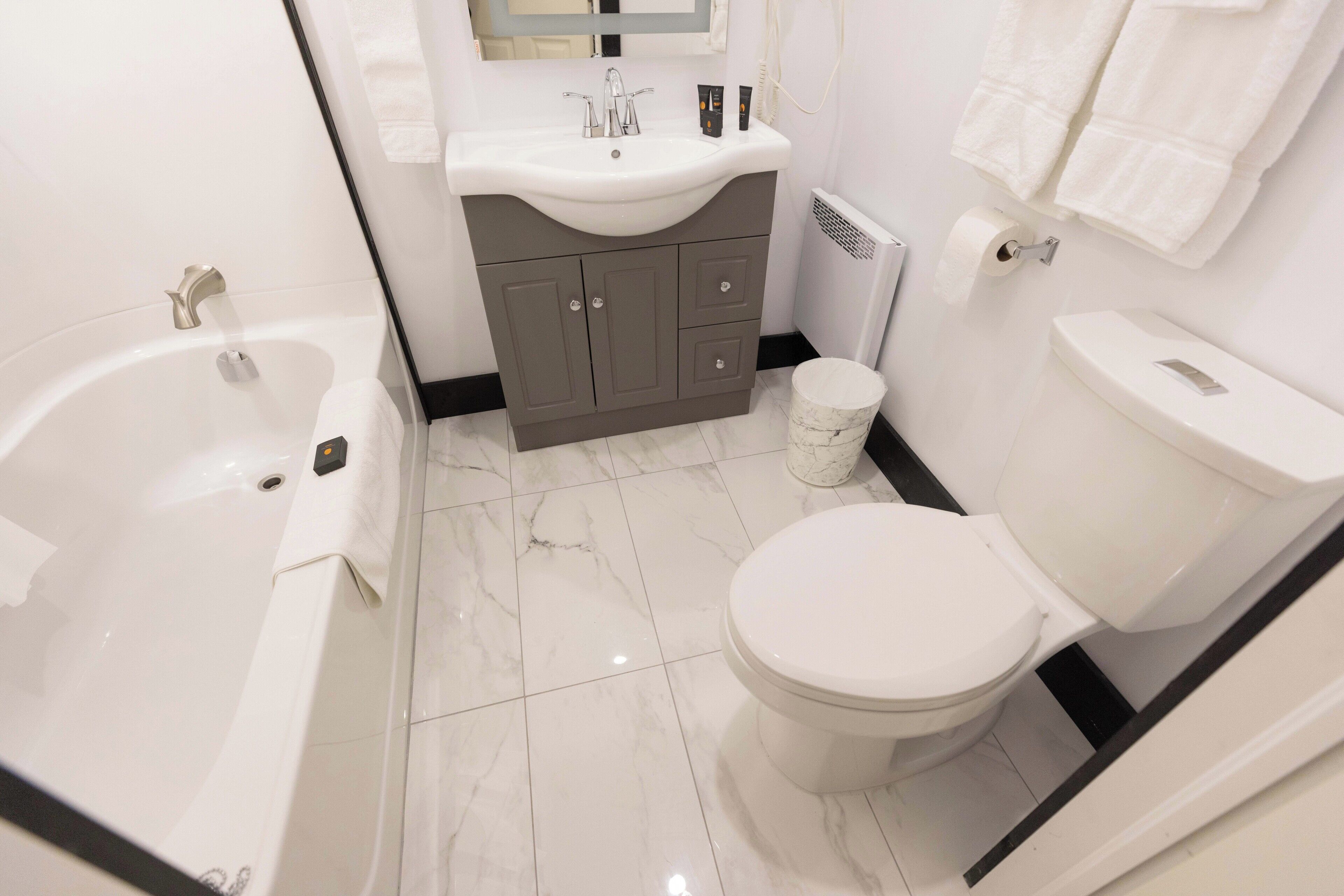 Un baño moderno con bañera, inodoro y tocador.