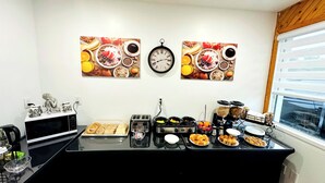 A breakfast buffet setup with various food items and a clock on the wall.