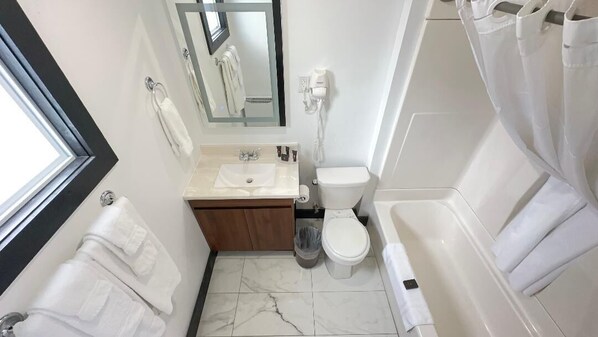 Un baño pequeño con lavamanos, inodoro y bañera.