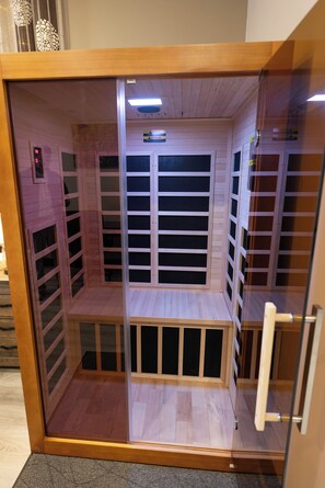 Un ascensor de madera con puerta de cristal, paneles de madera y una pequeña plataforma inferior.