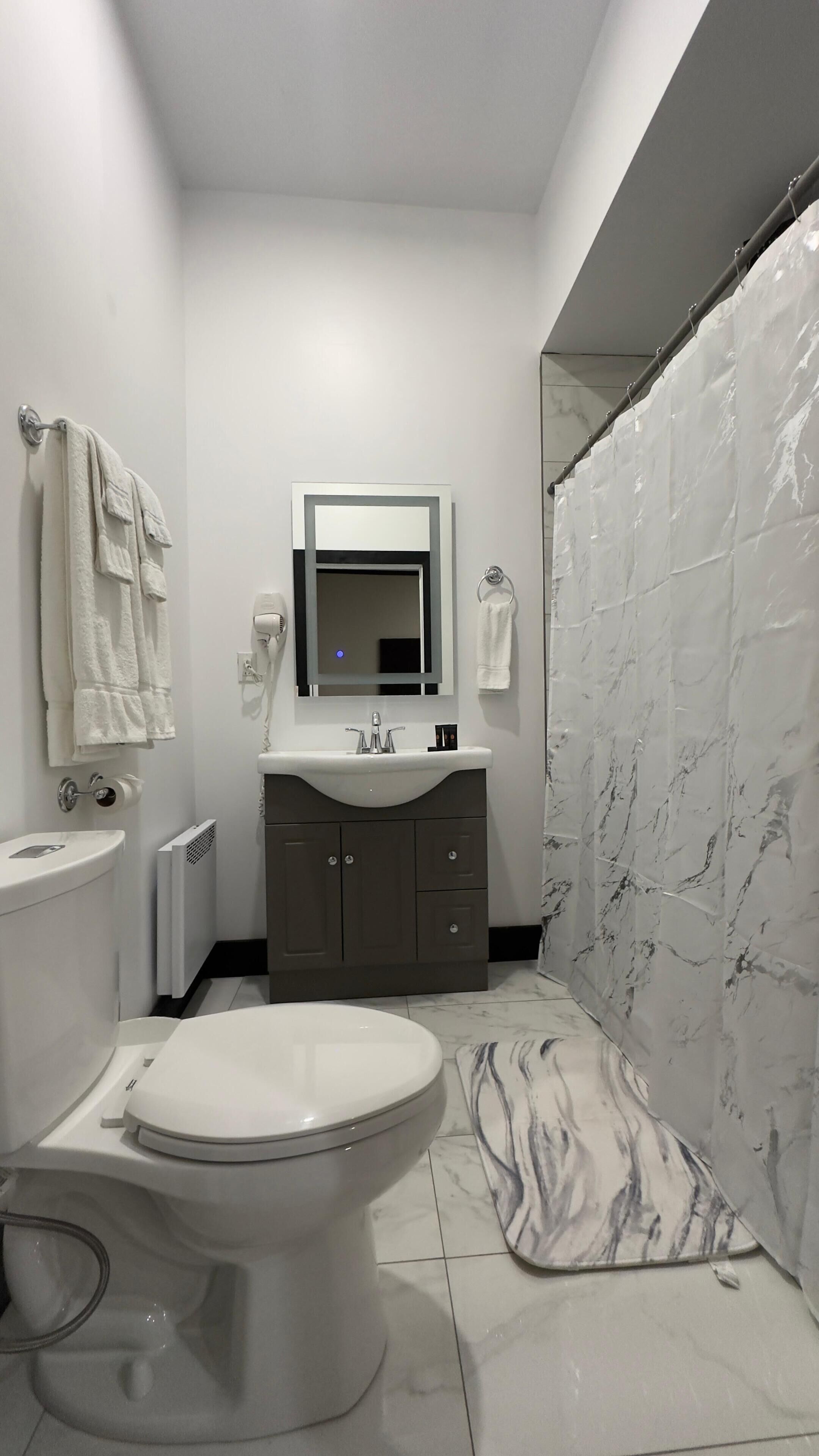 A modern bathroom with a toilet, sink, and shower area.