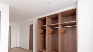 Un armadio a muro con diversi ripiani in legno e una barra per appendere i vestiti.