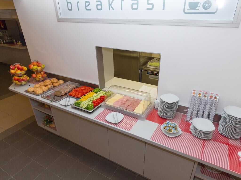 Een ontbijtbuffet met diverse gerechten en bestek.