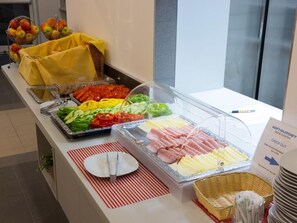 A buffet with various food items including sliced vegetables and meats. - Win Budget B&B (Wiener Neustadt)
