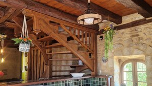 A rustic kitchen with wooden beams, a stone wall, a built-in sink, and a small window. - Maison Périgourdine Avec vue Magnifique, sur les Hauteurs de Sarlat (SARLAT LA CANEDA)