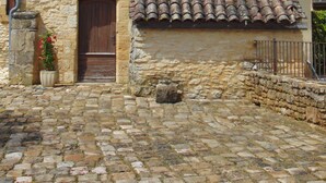 A stone building with a tiled roof, a wooden door, and a small window. - Maison Périgourdine Avec vue Magnifique, sur les Hauteurs de Sarlat (SARLAT LA CANEDA)