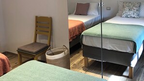 A bedroom with two beds, a chair, a small table, and a mirror. - Beautiful 2-bedroom apartment in Tirrenia (Tuscany) (Marina di Pisa-tirrenia-calambr)