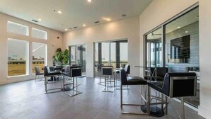 A spacious, modern hotel lobby with large windows, a reception desk, and seating areas. - Sexy & Sensual 1BR Escape (Dallas)