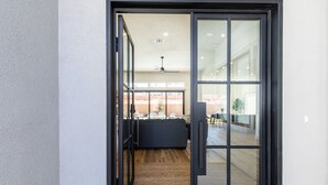A modern interior with a sliding glass door leading to a living area with a sofa, a rug, and a ceiling fan.
