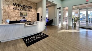 A reception area with a stone wall, a reception desk, and a sign that reads 'Windsor Island Resort.' - Luxurious Pool Home With Private Pool-2061lc 8 Bedroom Home by RedAwning (Davenport)