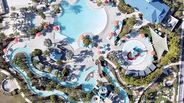 An aerial view of a resort with a large central pool, multiple water slides, and sun loungers. - Luxurious Pool Home With Private Pool-2061lc 8 Bedroom Home by RedAwning (Davenport)