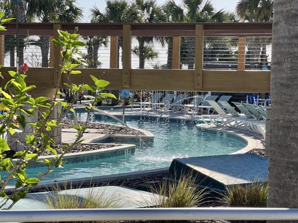 Un espace piscine doté de plusieurs éléments aquatiques et de chaises longues.
