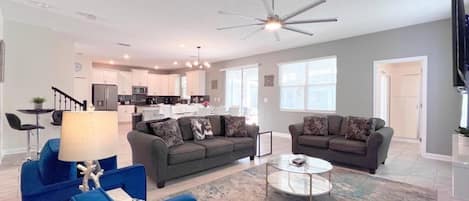 A modern living room with two sofas, a coffee table, and a TV.