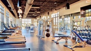Un gimnasio con cintas de correr, máquinas de pesas y mancuernas.