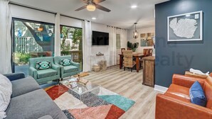 A modern living room with a sofa, a coffee table, and a dining area with a table and chairs.