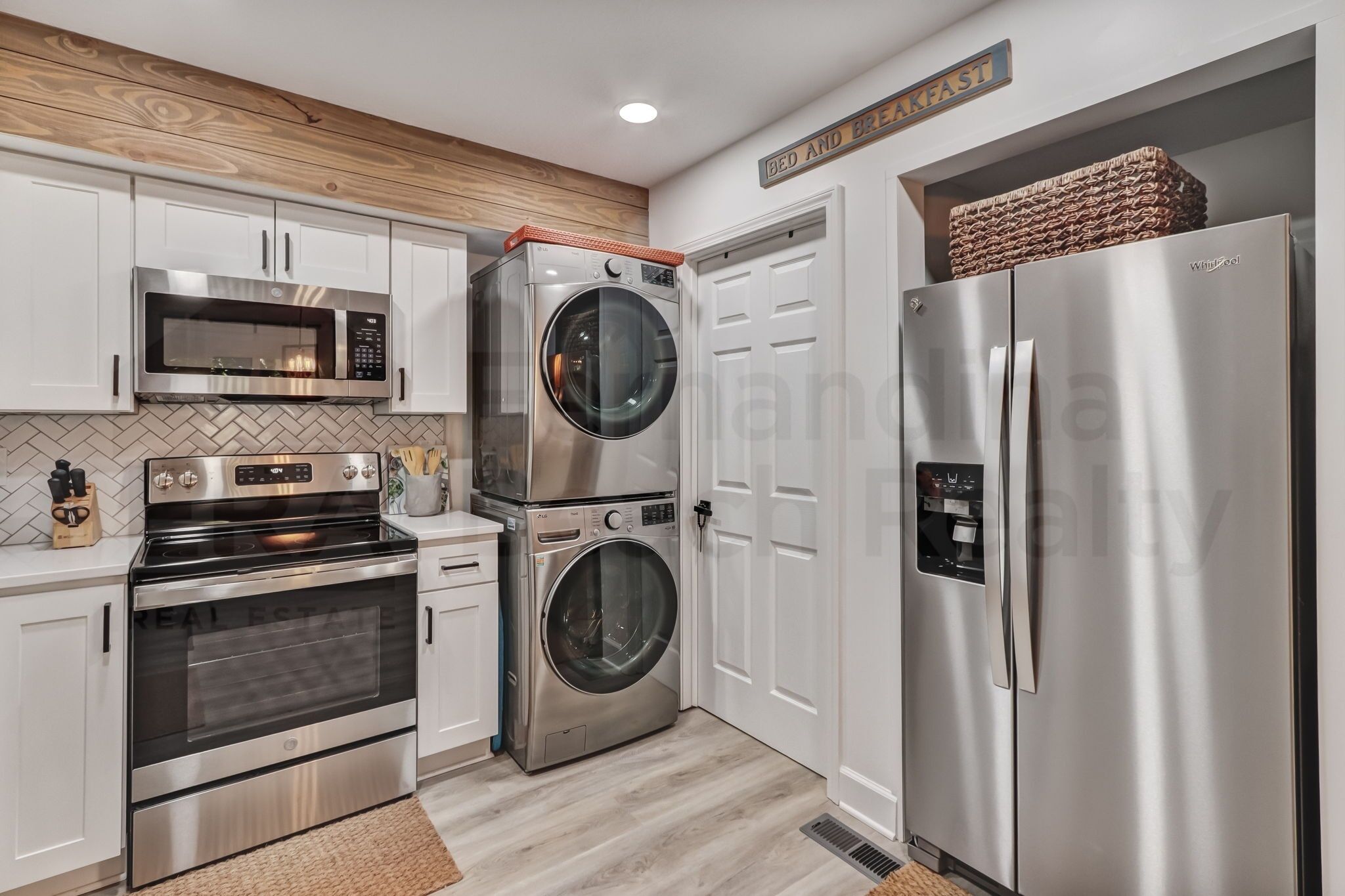 A modern kitchen with stainless steel appliances, a microwave, oven, and a refrigerator.