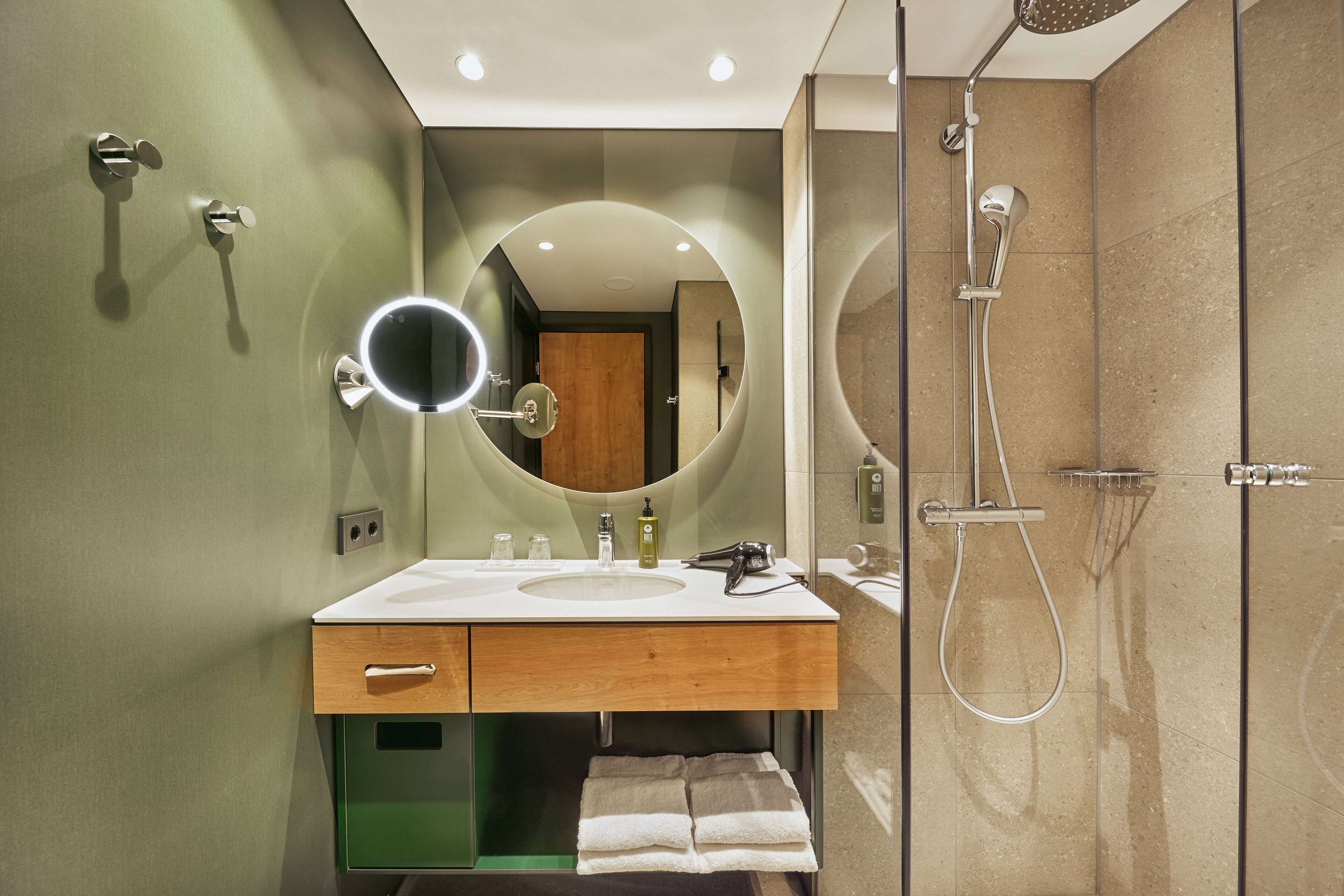 A modern bathroom with a vanity, mirror, and shower.