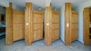 Eine Reihe Holztüren mit Hinweisschildern mit dem Schriftzug „EQUALITY“, die geschlechterneutrale Toiletten kennzeichnen.