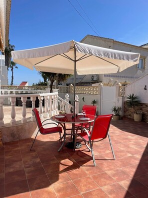 An outdoor patio with a table and chairs, a white umbrella, and a white railing. - Traditional Villa with Private Pool SM591 (San Miguel de Salinas)
