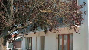 A building with a patio area featuring outdoor furniture and a tree. - Pretty F2 1 to 4 persons 2 (L'Aiguillon-la-Presqu'île)