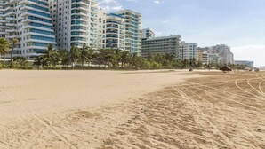 Ein Strand mit Hochhäusern im Hintergrund.