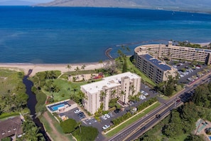A hotel with a pool, parking, and a view of the ocean. - Koa Lagoon- Beachfront - Spectacular Location with Incredible Views (KIHEI)
