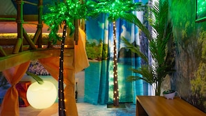 A room with a wooden bench, a small table, and a wall with a mural.