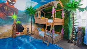 A room with a bunk bed, tropical wall decor, a mural, and a small pool.