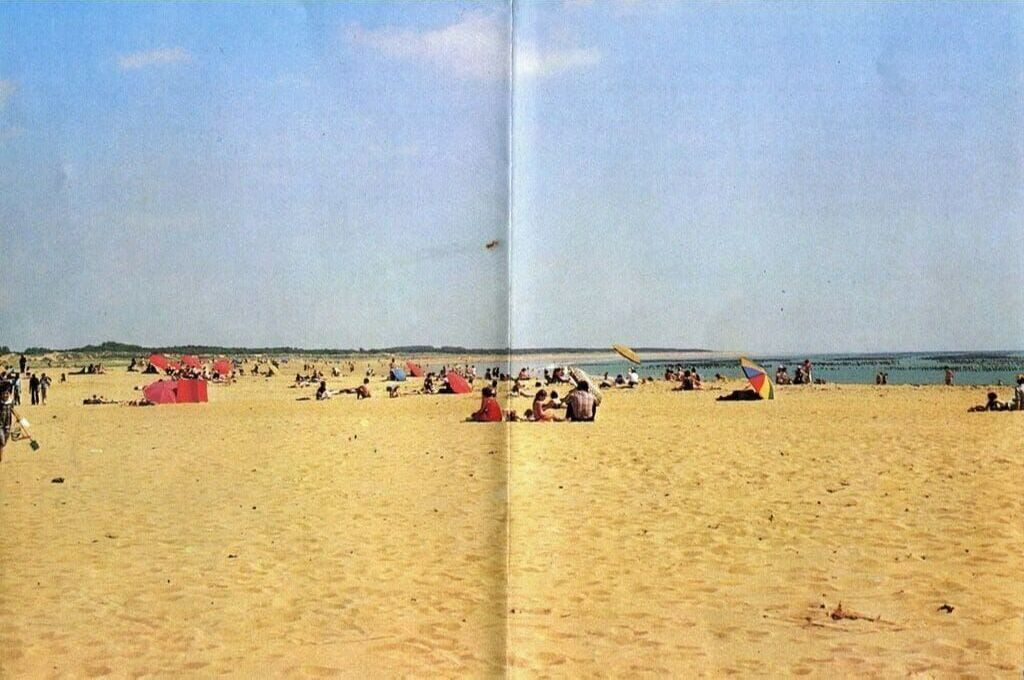 En strand med folk och tält.