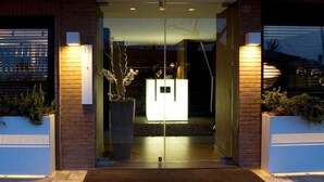 A hotel entrance with a glass door, a reception desk, and a number sign '13' above it. - HOTEL SALUS (Pescara)