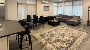 A modern living room with a dining area, a sofa, a coffee table, and a patterned rug. - Bright Townhome in Trendy Ballard (Seattle)