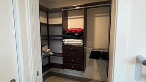 A walk-in closet with a mirrored closet rod, a hanging rack, and a set of drawers. - Bright Townhome in Trendy Ballard (Seattle)
