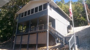 Um edifício de dois andares com varanda e escadaria que leva ao andar superior.