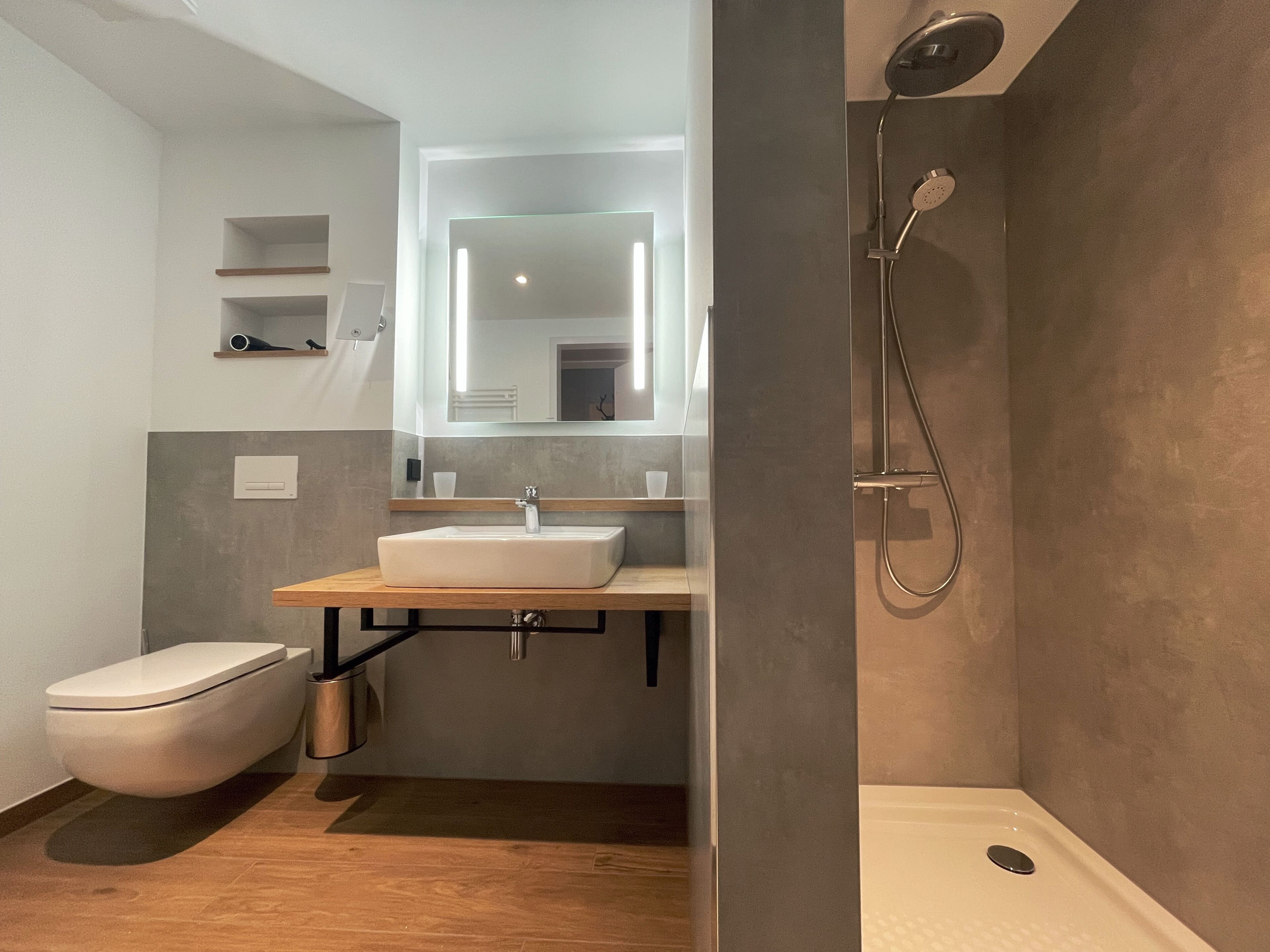 A modern bathroom with a toilet, sink, and shower.