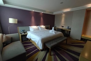 A hotel room with a large bed, a bench, a bedside table, a lamp, and a mirror. - Lavande Hotel (Huawei Gangtou Metro Station) (Shenzhen)