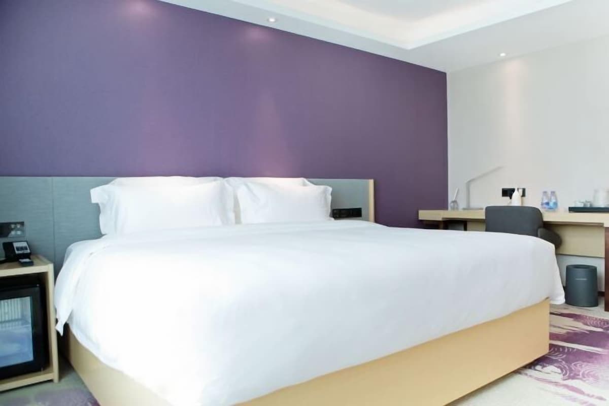 A hotel room with a bed, a desk, and a chair.