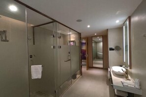 A modern bathroom with a glass-enclosed shower, a vanity with a sink, and a large mirror. - Lavande Hotel Huawei Gangtou Metro Station (Shenzhen)