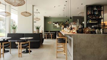 A modern bar area with a bar counter, seating, and a variety of bottles.