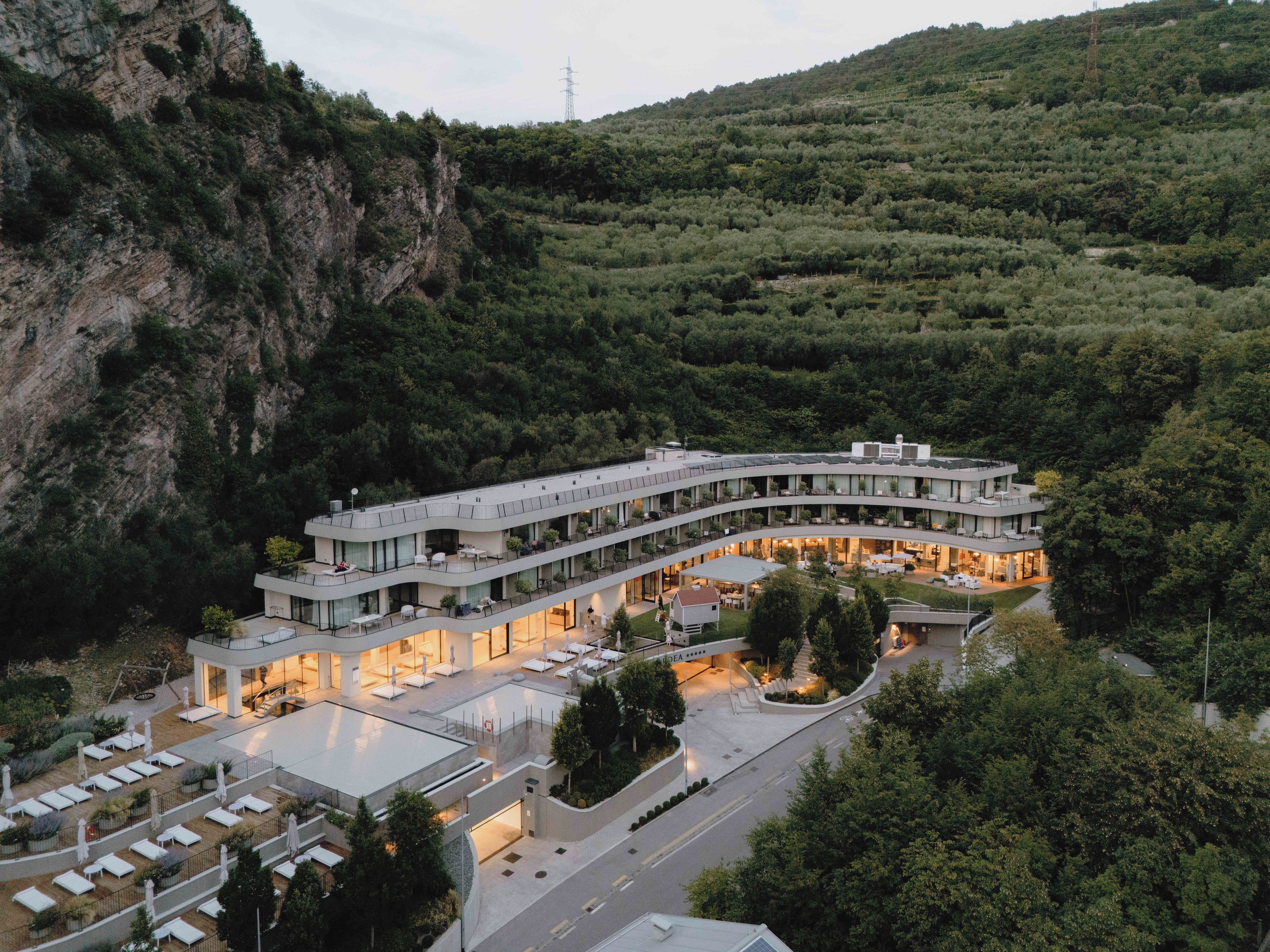 Un hotel moderno con arquitectura curva, varios balcones y un patio central.