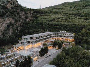 A modern hotel with a curved architecture, multiple balconies, and a central courtyard. - Gardea Soulfamily Resort (Nago-Torbole)