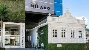 En byggnad med en skylt som visar texten ”CIDADE MILANO” och en annan skylt med texten ”JARDIM MILANO”.