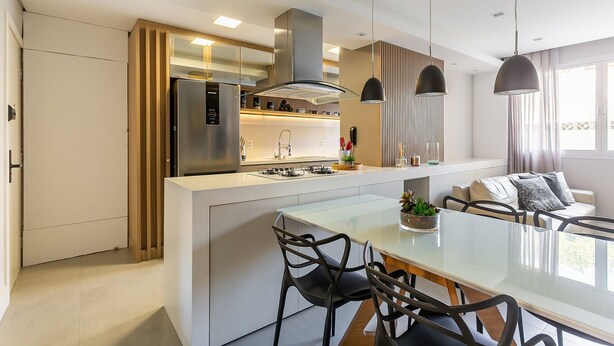 A modern kitchen with a central island, stainless steel appliances, pendant lighting, and a dining area with a glass table and chairs. - 200m from Beiramar Shopping | WI-FI 100mb #CA43 (Florianópolis)