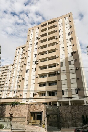 Un immeuble de grande hauteur doté de nombreux balcons et de plusieurs unités de climatisation.