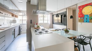 A modern kitchen with a central island, stainless steel appliances, and pendant lighting. - 200m from Beiramar Shopping | WI-FI 100mb #CA43 (Florianópolis)