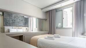 A modern hotel room with a large bed, a desk, and a large mirror. - 200m from Beiramar Shopping | WI-FI 100mb #CA43 (Florianópolis)