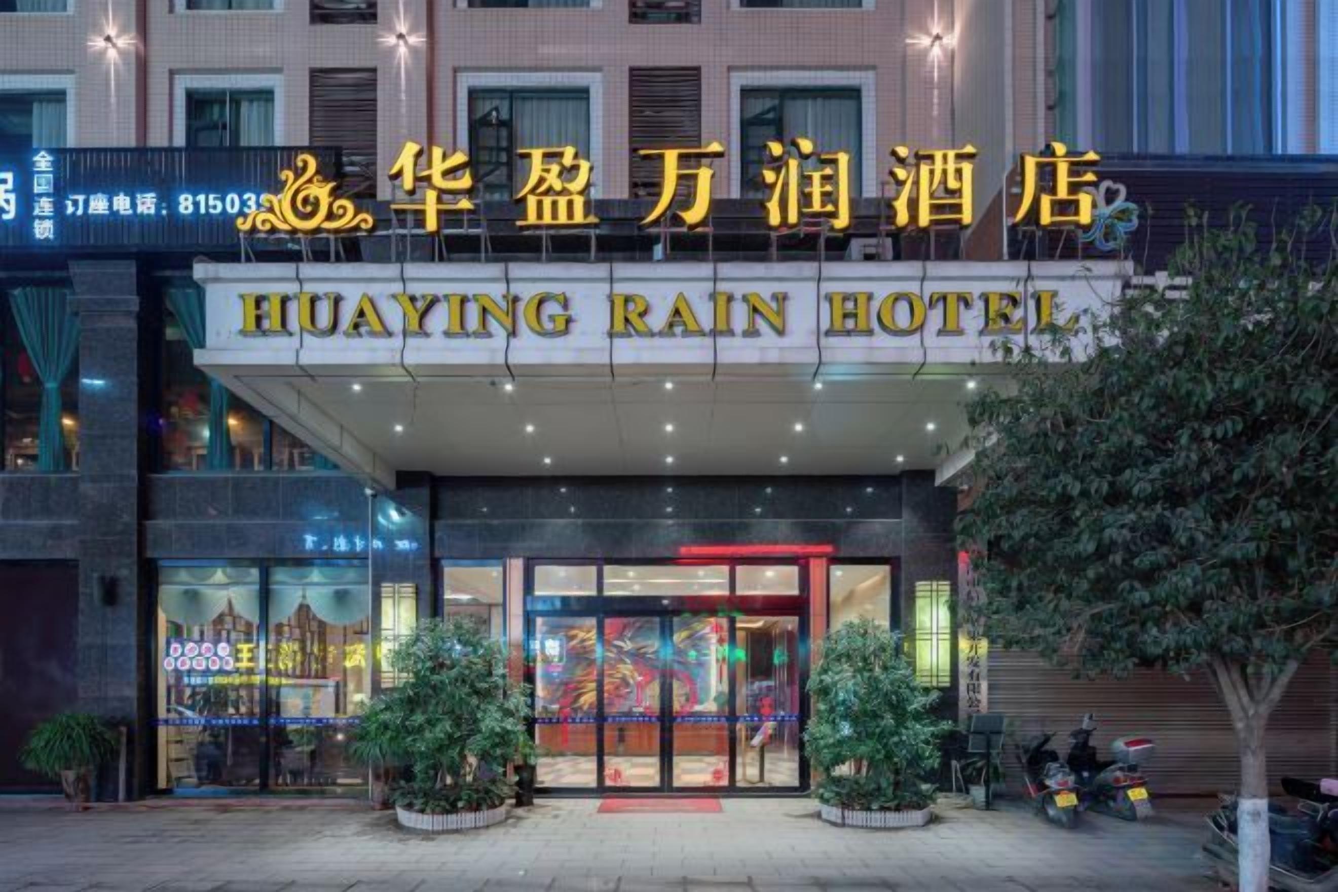 The Huaying Rain Hotel with a prominent entrance, potted plants, and a motorcycle parked outside.