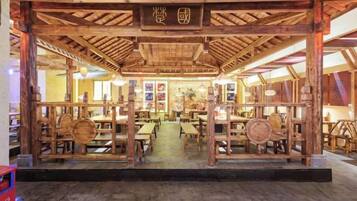 A traditional wooden structure with tables and chairs arranged for dining.